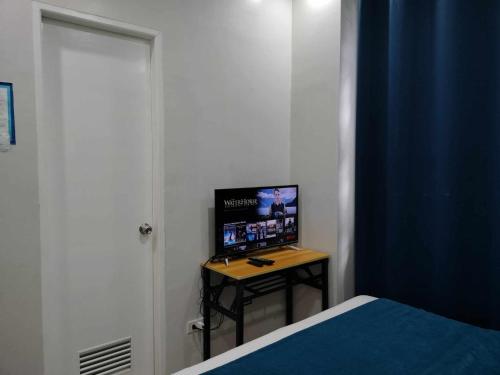 a bedroom with a bed and a television on a table at Luxurious Place Mountain View Spacious with WIFI Near SM Lucena in Lucena