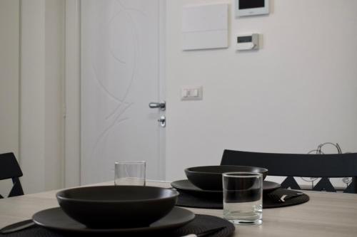 a table with two black bowls and a glass at Room 28 in Conversano