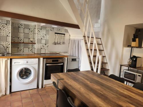 une cuisine avec un lave-linge et une table en bois dans l'établissement La maison de corse, à Feliceto