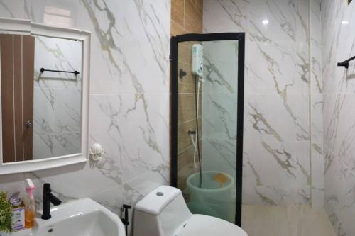 a bathroom with a shower and a toilet and a sink at โฮมสเตย์บ้านญาติมุกดาหาร in Ban Muang Ba