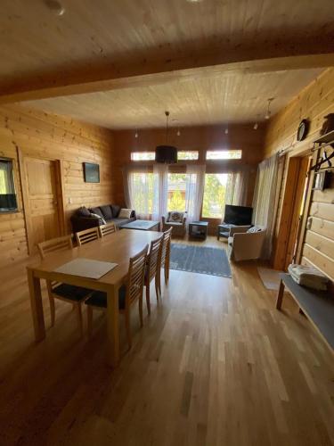 a large living room with a table and chairs at Mukava mökki kompleksi Saimaan rannalla in Mikkeli