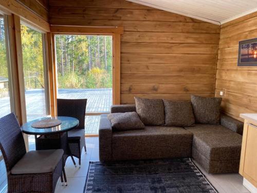 a living room with a couch and a table at Mukava mökki kompleksi Saimaan rannalla in Mikkeli