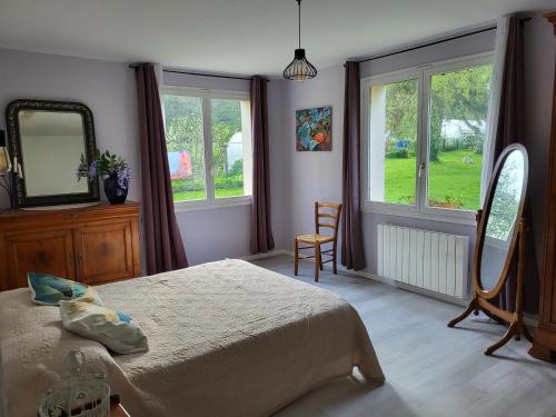 une chambre avec un lit, un miroir et une chaise dans l'établissement lacampagneenchantée, à Madeleine