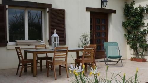 une table et des chaises en bois devant une maison dans l'établissement lacampagneenchantée, à Madeleine