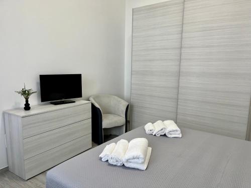 a bedroom with two towels on a bed with a tv at Room 28 in Conversano
