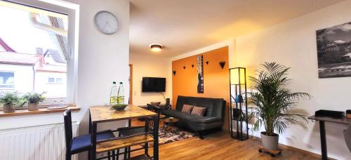 a living room with a couch and a chair and a clock at Apartment Stadtliebe Marburg PS4 in Marburg an der Lahn