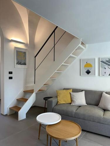 a living room with a couch and a staircase at Design, comfort e atmosfera nel cuore del Salento in Martano