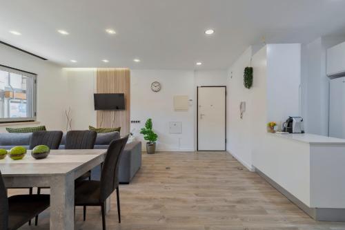 a kitchen and a living room with a table and a couch at Guest house in Barreiro