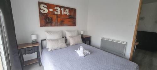 a bedroom with a bed with a white toy on it at Adorable gîte au calme in Angliers
