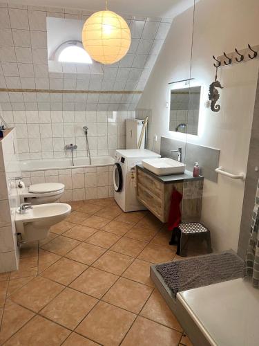 a bathroom with a sink and a washing machine at FeWo Strandgut in Großefehn 
