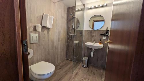 a bathroom with a shower and a toilet and a sink at The Vík Inn by Ourhotels in Vík
