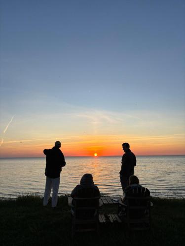 a group of people watching the sunset over the water at Viļņi in Ulmale