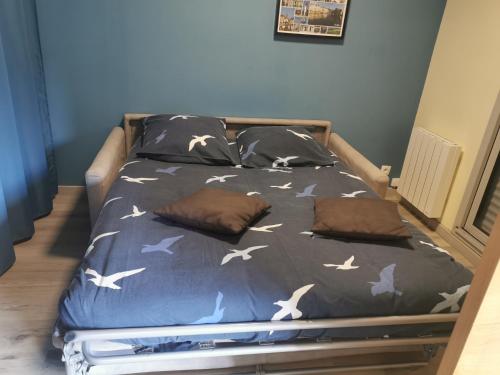 - un lit avec des oiseaux dans une chambre dans l'établissement Le bonheur au vert feuillage, à Honfleur