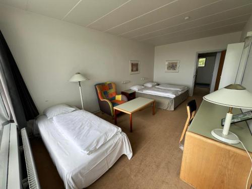 a hotel room with two beds and a table at Hotel Østersø in Aabenraa