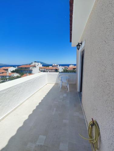 a white chair sitting on the edge of a balcony at HOTEL IREON beach in Samos