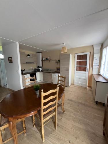 une cuisine et une salle à manger avec une table et des chaises en bois dans l'établissement Jenny House, à Lamotte-Beuvron