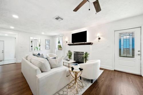 a white living room with a white couch and a fireplace at Cozy West Palm Beach Home l 10min to Municipal Beach and more! in West Palm Beach