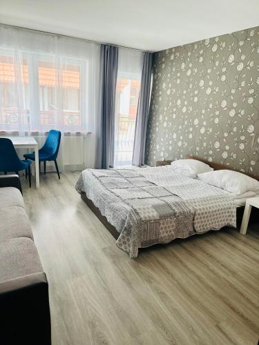 a bedroom with a bed and a table and chairs at Pokoje Sztormowa 15 in Pogorzelica