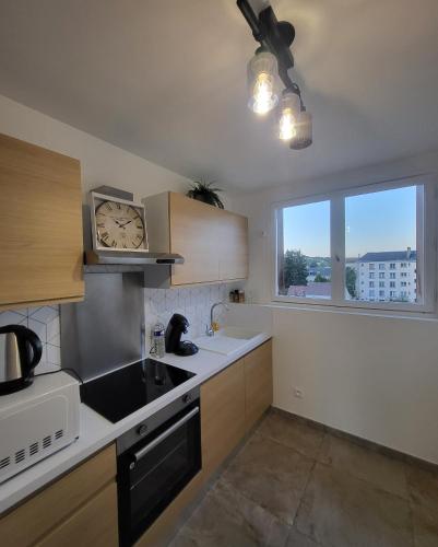 a kitchen with a sink and a clock on the wall at Pontoise bord de l oise in Pontoise