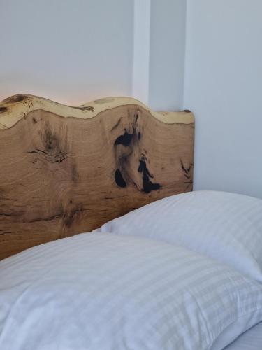 a bed with a wooden headboard in a bedroom at Smaro Studios in Firostefani