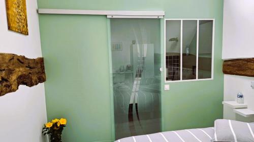 a glass cabinet in a room with a bed at La GRANGE D'AZE in Azé