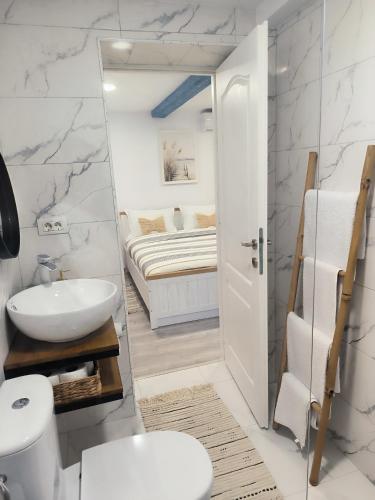 a bathroom with a sink and a toilet and a bed at Casa lui Matei Murighiol in Murighiol
