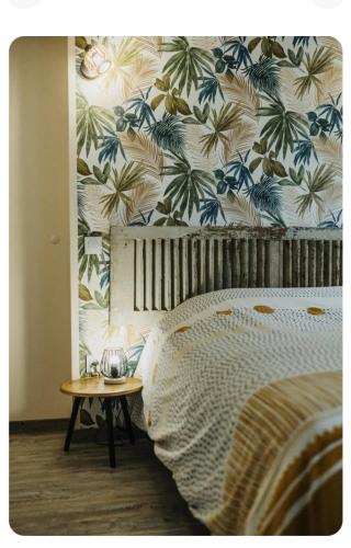 une chambre avec un lit avec un papier peint tropical dans l'établissement Le Key Largo, à Cherbourg en Cotentin