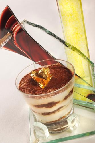 a glass bowl filled with chocolate pudding in front of a mirror at Demeure de Flore in Lacabarède