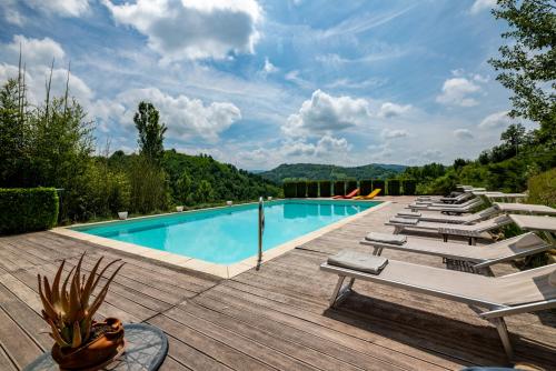 a pool with lounge chairs on a wooden deck at Tenuta Moncarlino in Morsasco