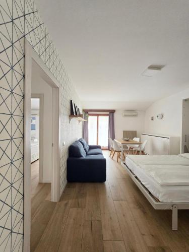 a bedroom with a bed and a couch in a room at Casa Barcelli Sport & Family Apartments in Nago-Torbole