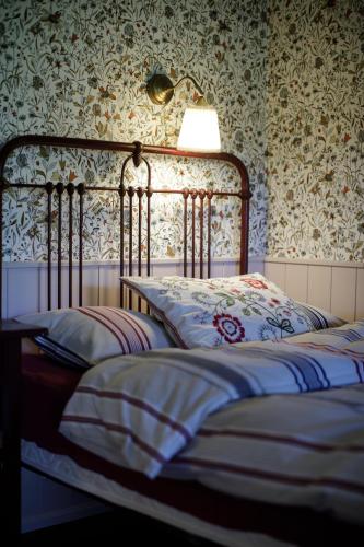 two beds in a bedroom with floral wallpaper at Muhu Tõnise Talu in Liiva