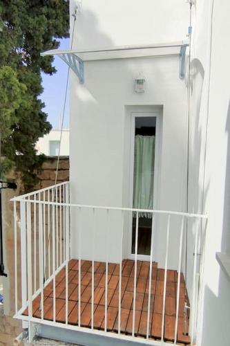 a balcony of a white house with a door at Terrazza Nostromo Francesco in Trani