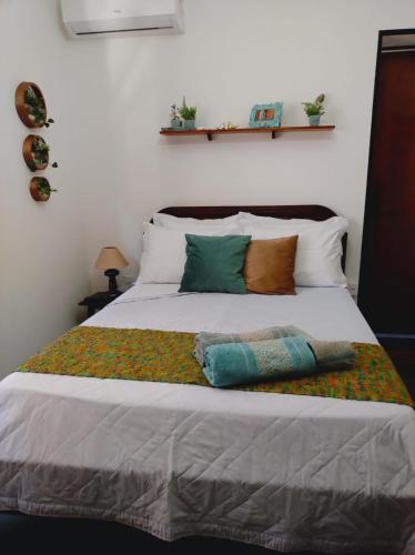 a bed with several pillows on top of it at Hospedaria Canto do Vinhedo in Espirito Santo Do Pinhal