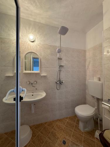 a bathroom with a toilet and a sink and a shower at Hotel Laguna - Guest House in Primorsko