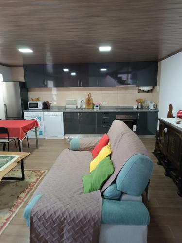 a living room with a couch with colorful pillows at Moradia Largo do Pátio in Sertã