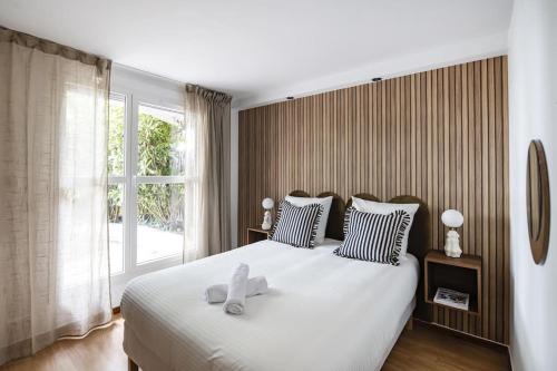 une chambre avec un grand lit blanc avec une fenêtre dans l'établissement Playground Suite, à Créteil