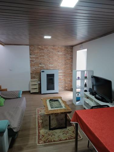 a living room with a table and a fireplace at Moradia Largo do Pátio in Sertã