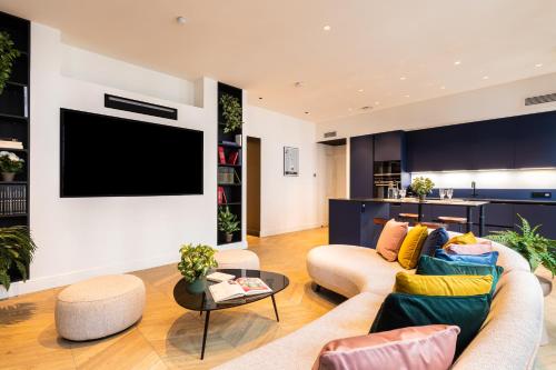 a living room with a couch and a tv at MOHOM - Bellecordière in Lyon