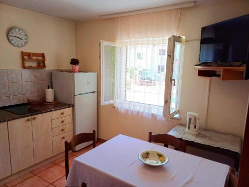 a kitchen with a white table and a white refrigerator at More in Crikvenica