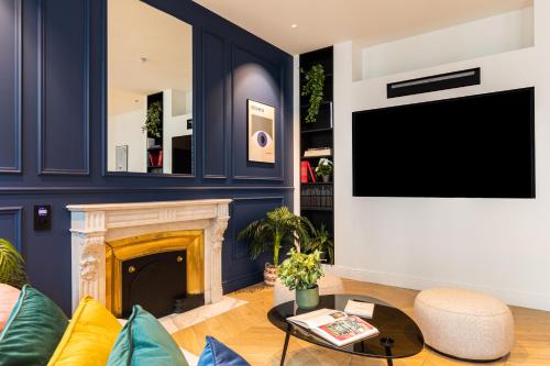 a living room with a fireplace and a tv at MOHOM - Bellecordière in Lyon