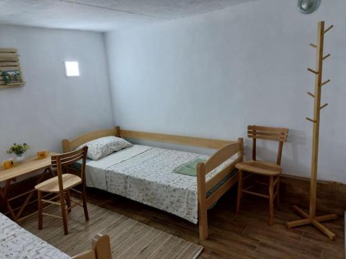 a bedroom with a bed and a table and chairs at Magarija 2 in Dimitrovgrad