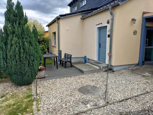 a patio with a table and a bench next to a house at Ferienwohnung am See in Großsteinberg