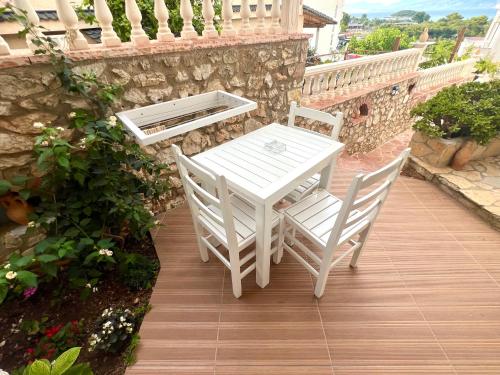 a white table and two chairs on a deck at ILLYRIAN hotel Ksamil in Ksamil