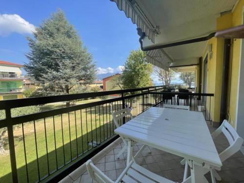 a white table and chairs on a balcony at Garda Paola Lake Experience 2 in Manerba del Garda