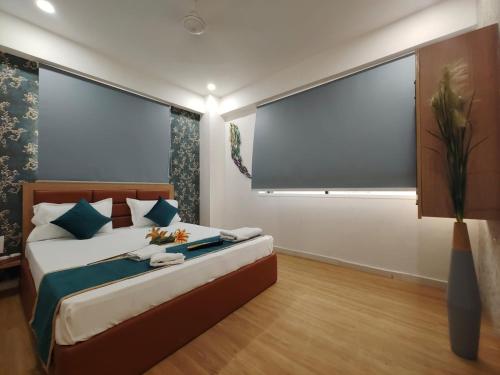 a bedroom with a bed with a large window at Hotel PRASANG in Surat