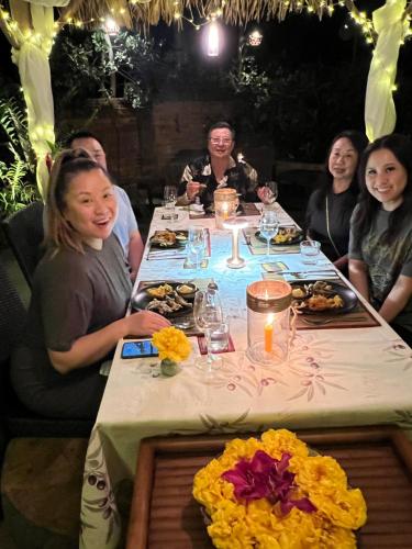 a group of people sitting around a table with food at Kanlaya's Eyrie, Luxury Homestay in Pang Mapha