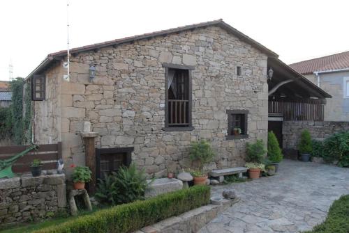 a stone building with a bench in front of it at Lareira rural apartamento Ribeira Sacra Chantada in Chantada