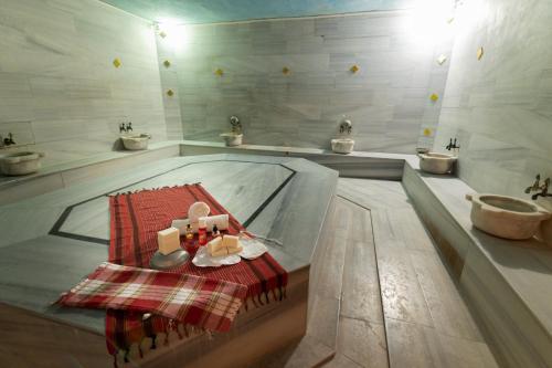 a bathroom with a tub with a tray of food at Grand Hotel Derin-All Inclusive in Beldibi