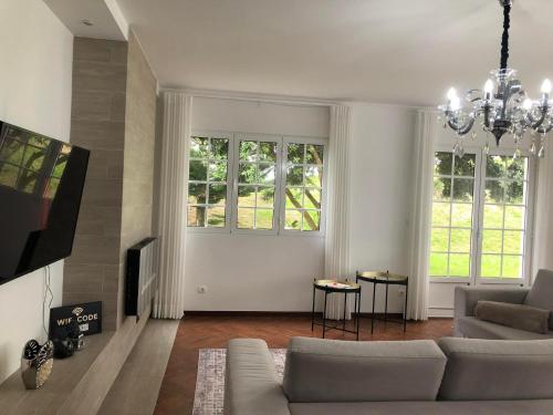 a living room with a couch and a tv at Vivenda Flor in Ponta Delgada
