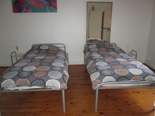 deux lits côte à côte dans une pièce dans l'établissement Appartement courte durée F1, à Bron